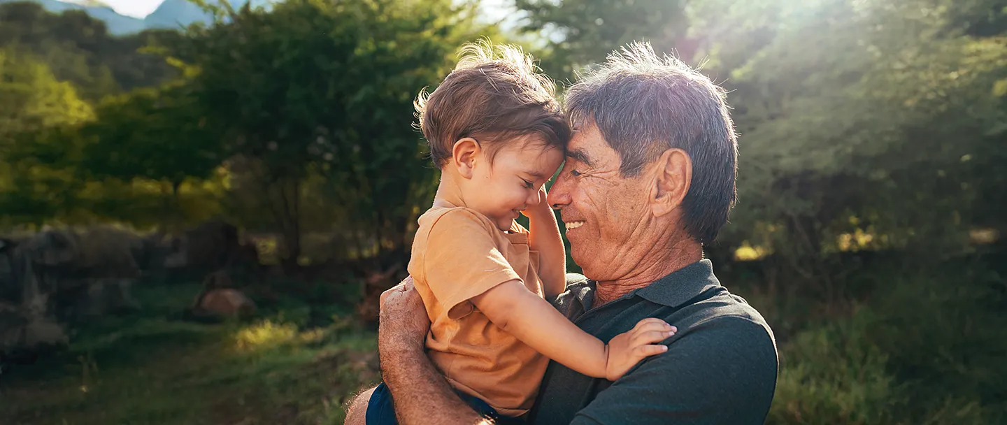 Verspielter Großvater verbringt an sonnigen Tagen Zeit mit seinem Enkel im Park.