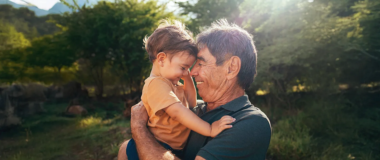 Verspielter Großvater verbringt an sonnigen Tagen Zeit mit seinem Enkel im Park.
